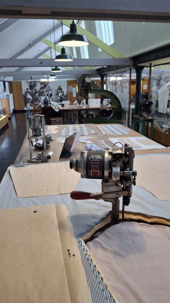 photo d'un atelier reconstitué, avec outils de coupe de patron de chemise